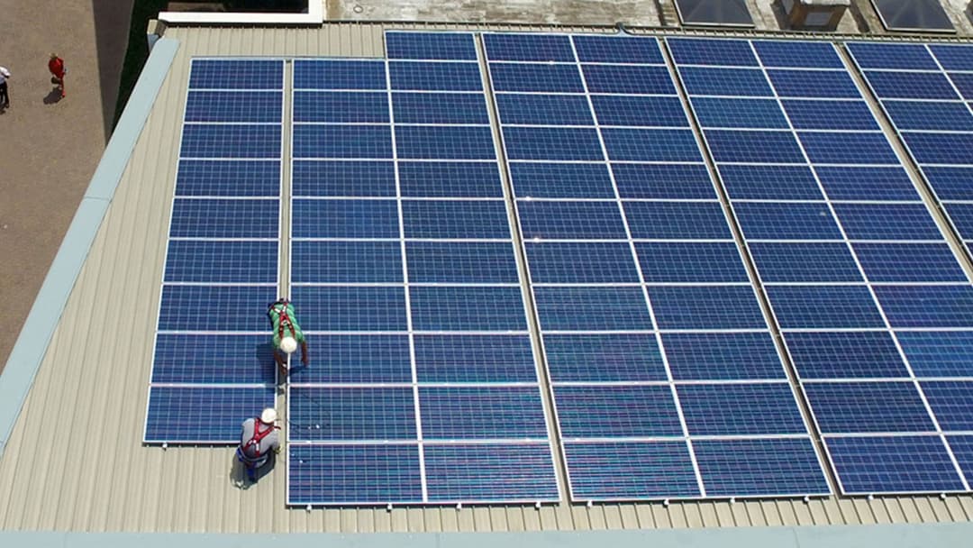 Installateur solaire qualifié posant des panneaux sur une toiture