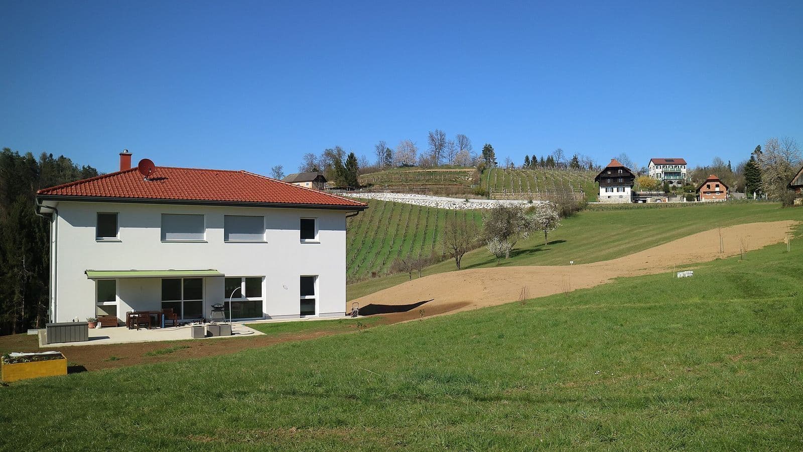 Maison individuelle contemporaine à toiture à deux pans, dans un paysage de campagne